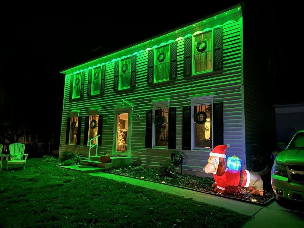 Colonial home with vivid green roofline lighting