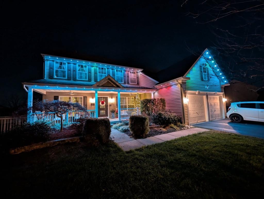 Craftsman home with multicolor roofline lighting and garage