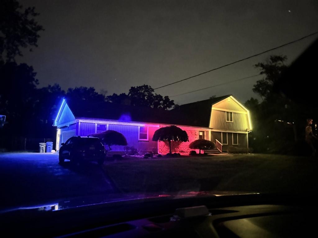 Ranch home with blue, purple and red roofline lighting at night