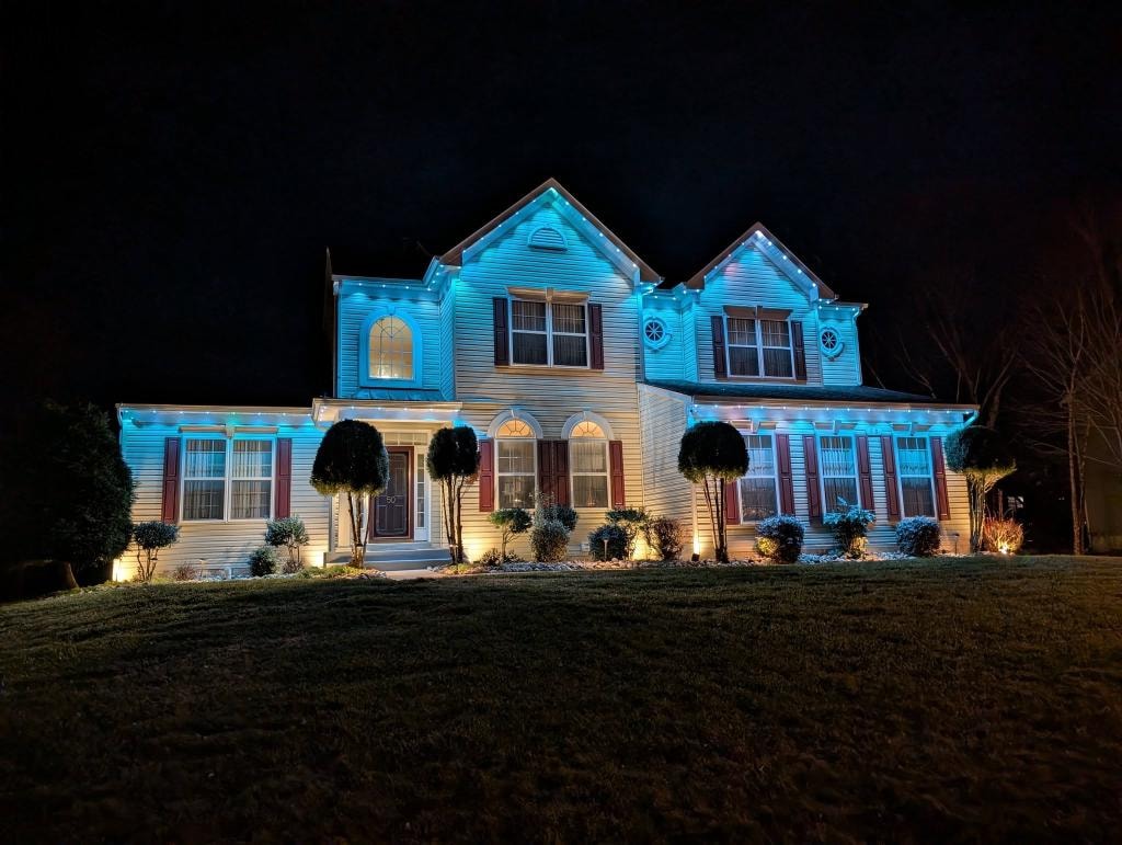 Two-story colonial home with teal roofline lighting